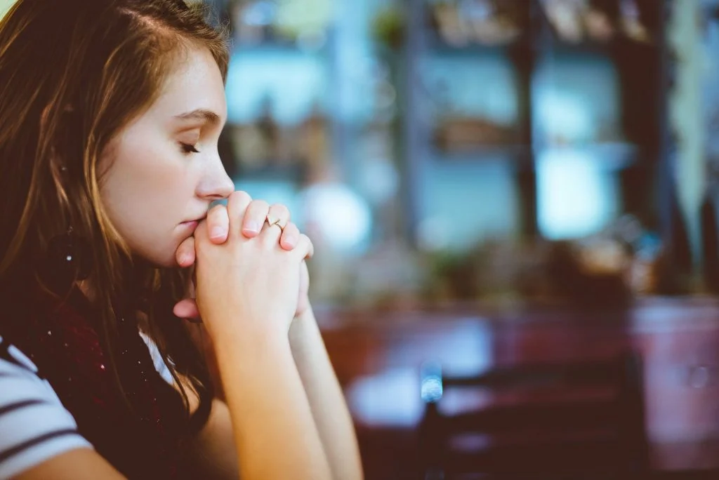 Woman with eyes closed in coffee shop