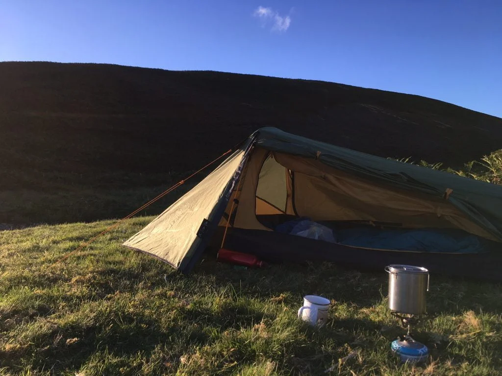 Small tent in front of a hill
